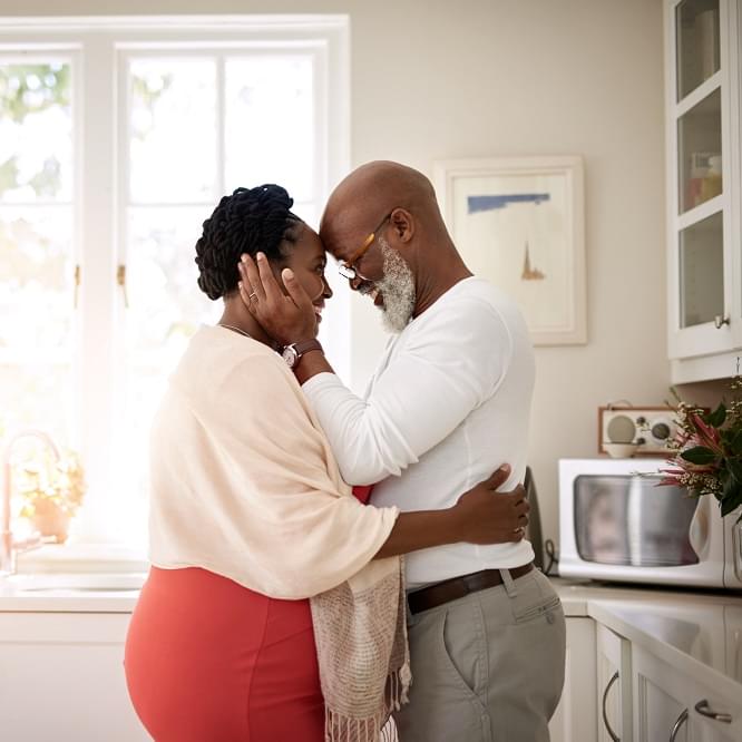 A couple embracing in their kitchen